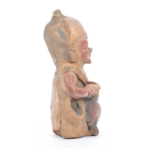 243 - A 20th century South American clay figure, possibly Ecuadorian. Tribal figure playing drum in seated... 