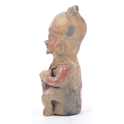 243 - A 20th century South American clay figure, possibly Ecuadorian. Tribal figure playing drum in seated... 