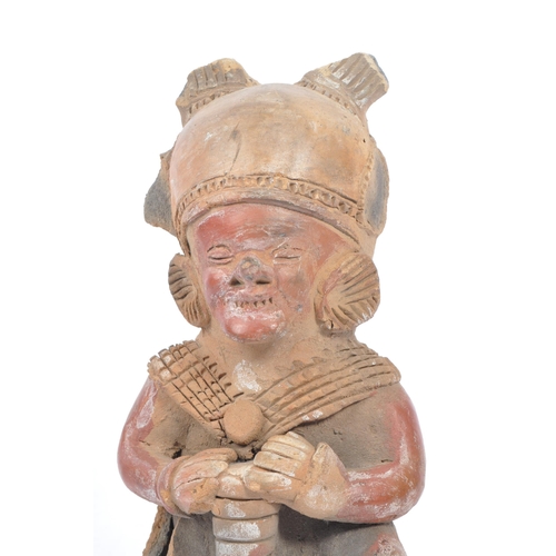 243 - A 20th century South American clay figure, possibly Ecuadorian. Tribal figure playing drum in seated... 