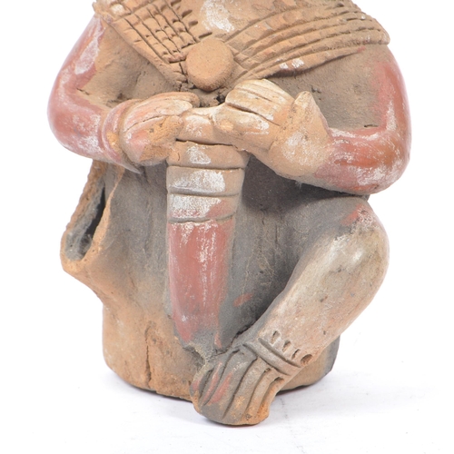 243 - A 20th century South American clay figure, possibly Ecuadorian. Tribal figure playing drum in seated... 