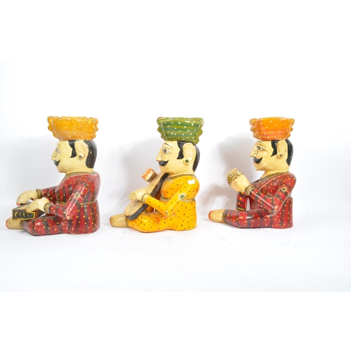 247 - Three 20th century Rajasthani Indian Bawla band carved wooden figures. The figures each in a seated ... 