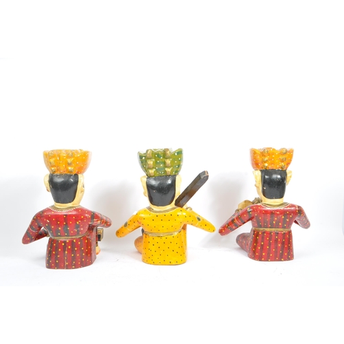 247 - Three 20th century Rajasthani Indian Bawla band carved wooden figures. The figures each in a seated ... 