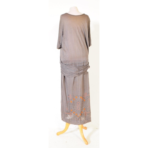 282 - A 1920s era Canadian beaded rayon dress in grey with vibrant orange beads decorating repeated patter... 