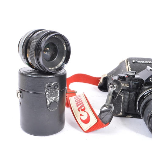 297 - Canon - A 20th century circa 1980s Canon A-1 35mm SLR camera and lenses. The camera in black leather... 