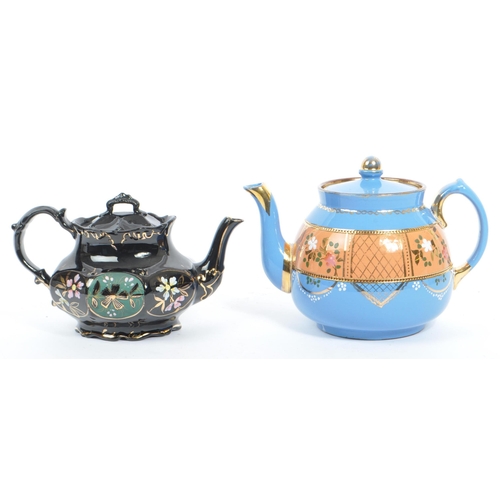 37 - Two hand decorated ceramic teapots, one by Wades. The teapots of blue and black colourways with hand... 