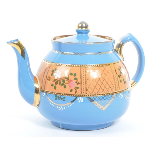 37 - Two hand decorated ceramic teapots, one by Wades. The teapots of blue and black colourways with hand... 