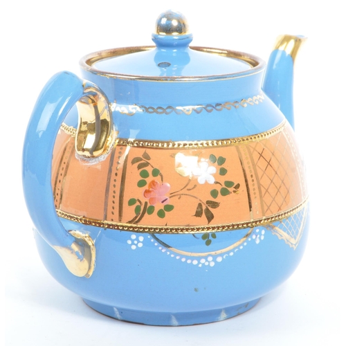 37 - Two hand decorated ceramic teapots, one by Wades. The teapots of blue and black colourways with hand... 