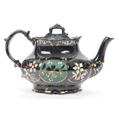 37 - Two hand decorated ceramic teapots, one by Wades. The teapots of blue and black colourways with hand... 