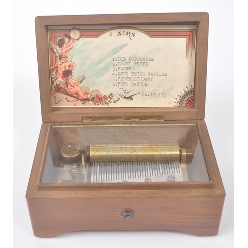 423 - A 20th century Harrods '6 Airs' music box in original box. The music box having a walnut veneer exte... 