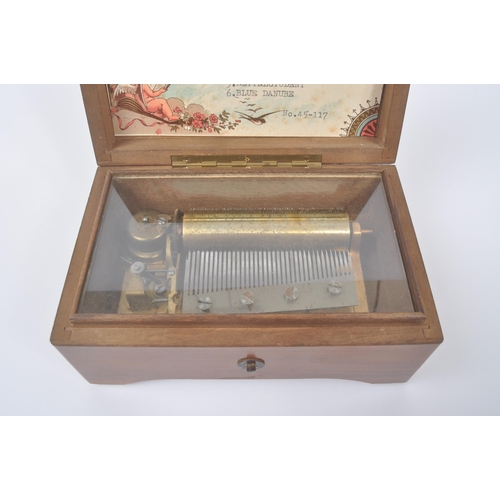 423 - A 20th century Harrods '6 Airs' music box in original box. The music box having a walnut veneer exte... 