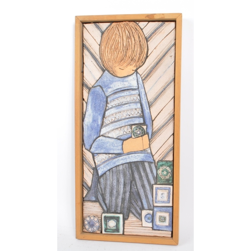 47 - A vintage 1970s ceramic wall plaque by Sheila Stapleton. Plaque depicting a young girl picking styli... 