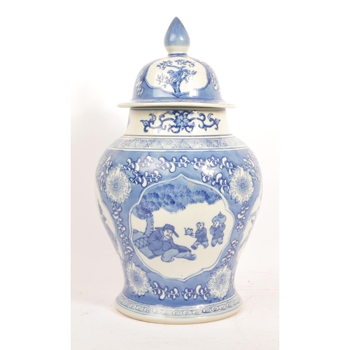 75 - A large 20th Century chinese porcelain china hand painted blue and white lidded vase / jar depicting... 