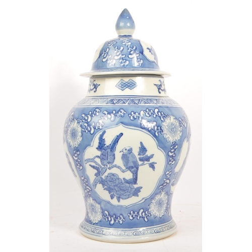 75 - A large 20th Century chinese porcelain china hand painted blue and white lidded vase / jar depicting... 