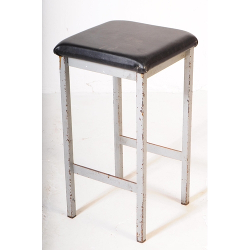 599 - Two 20th century metal construct bar stools. Of square form with black leatherette padded seat. On s... 