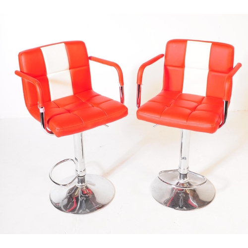 607 - A pair of mid 20th century circa 1970s red and white vinyl and chrome bar stool chairs. The chair ha... 