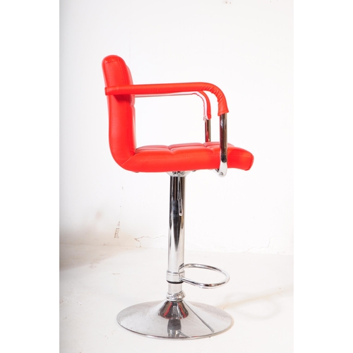 607 - A pair of mid 20th century circa 1970s red and white vinyl and chrome bar stool chairs. The chair ha... 