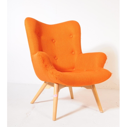 610 - A mid 20th century wingback armchair in the manner of Ercol 236 tub chair. The chair having wing bac... 