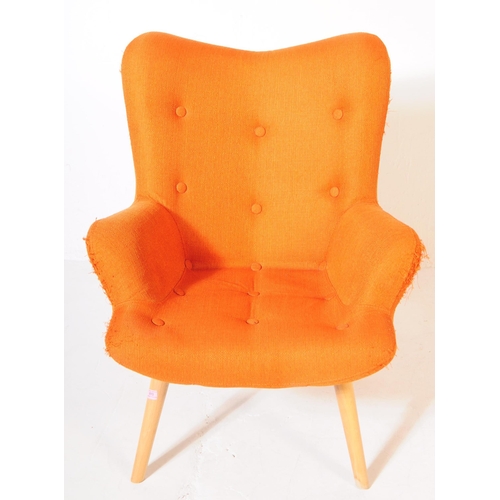 610 - A mid 20th century wingback armchair in the manner of Ercol 236 tub chair. The chair having wing bac... 