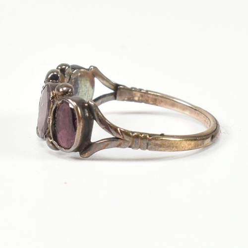 100 - A Georgian gold and garnet four stone ring. The Georgian ring having four bezel set flat cut garnets... 