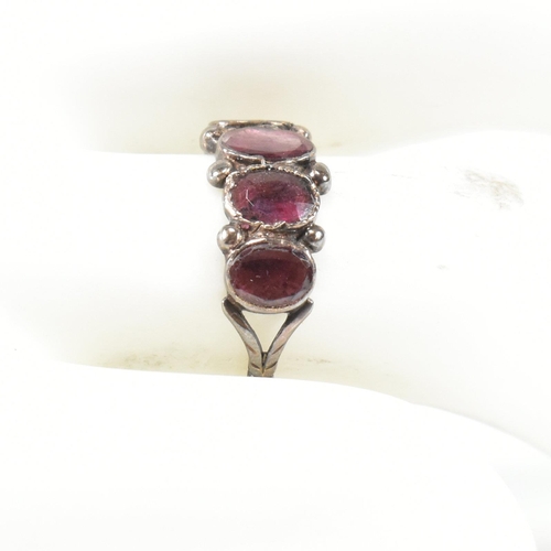 100 - A Georgian gold and garnet four stone ring. The Georgian ring having four bezel set flat cut garnets... 