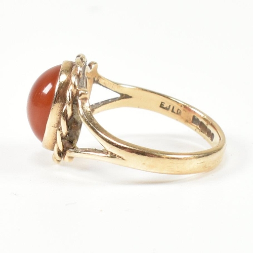 114 - A hallmarked 9ct gold and carnelian ring. The ring set with a carnelian cabochon framed with a rope ... 