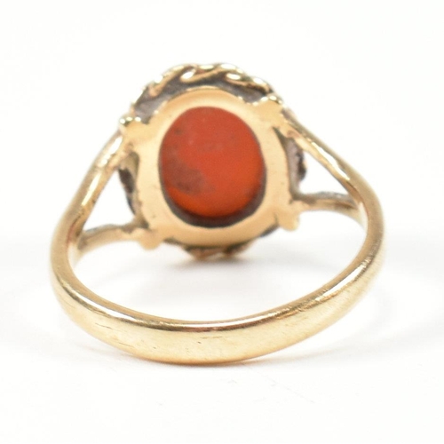 114 - A hallmarked 9ct gold and carnelian ring. The ring set with a carnelian cabochon framed with a rope ... 