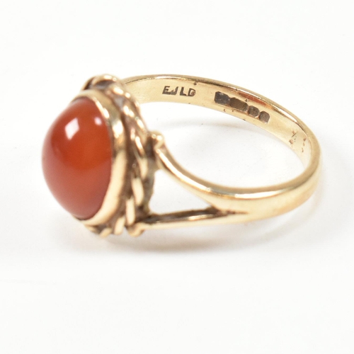 114 - A hallmarked 9ct gold and carnelian ring. The ring set with a carnelian cabochon framed with a rope ... 