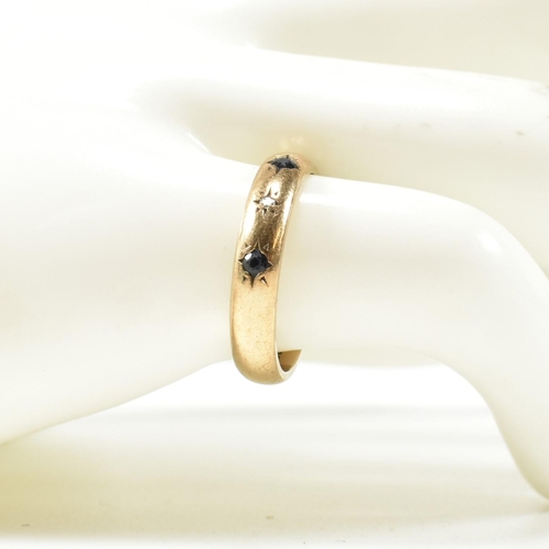 115 - A hallmarked 9ct gold, sapphire and diamond band ring. The gold band ring set with four star set rou... 