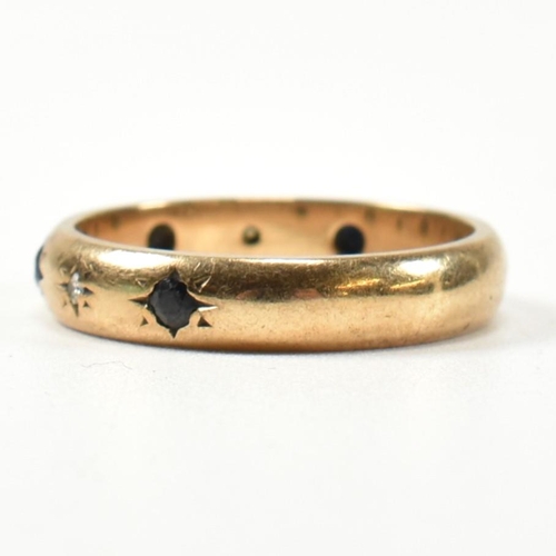 115 - A hallmarked 9ct gold, sapphire and diamond band ring. The gold band ring set with four star set rou... 