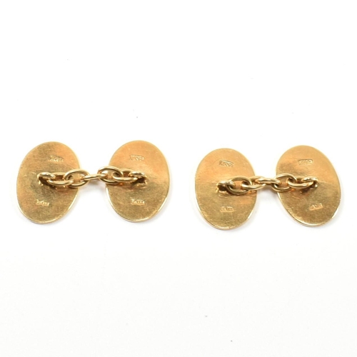 12 - A pair of hallmarked 18ct gold cufflinks. The cufflinks having oval heads with engine turned decorat... 