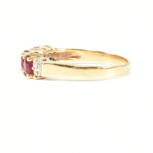 120 - A hallmarked 18ct gold ruby and diamond three stone ring. The ring having three button prong set ova... 