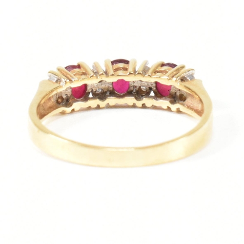 120 - A hallmarked 18ct gold ruby and diamond three stone ring. The ring having three button prong set ova... 