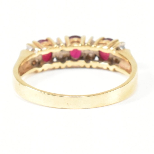 120 - A hallmarked 18ct gold ruby and diamond three stone ring. The ring having three button prong set ova... 