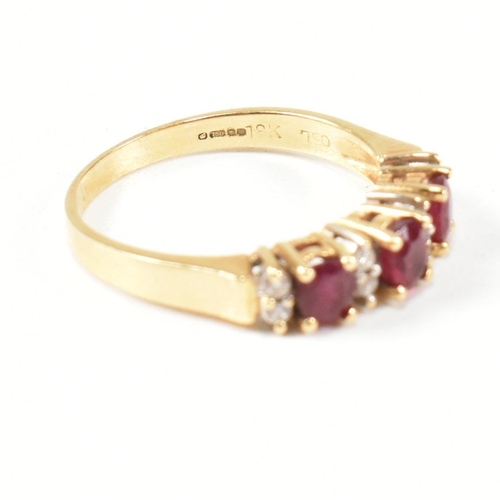 120 - A hallmarked 18ct gold ruby and diamond three stone ring. The ring having three button prong set ova... 