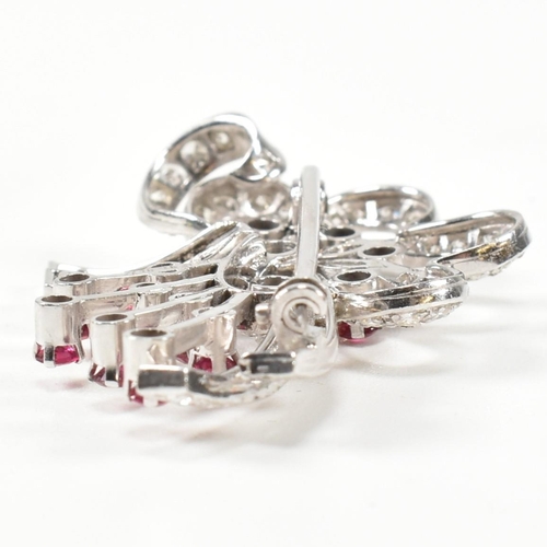 13 - An Art Deco white gold ruby and diamond white spray brooch pin. The brooch set with a central round ... 