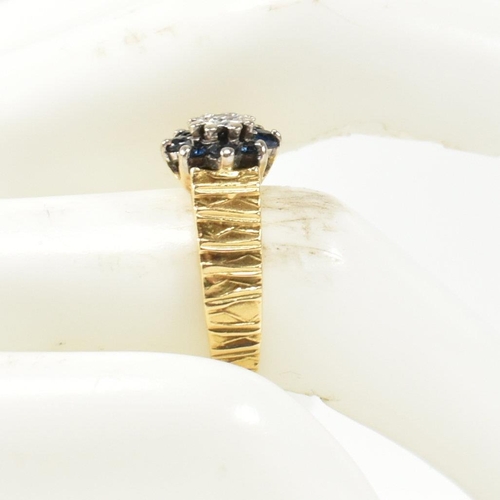 141 - A hallmarked 18ct gold, diamond and sapphire cluster ring. The cluster ring having a central star se... 