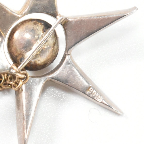 143 - An antique silver and paste star brooch pin. The brooch in the form of an eight pointed star set wit... 