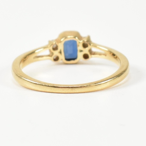 144 - An 18ct gold sapphire and diamond ring. The ring having a central bezel set emerald cut sapphire fla... 