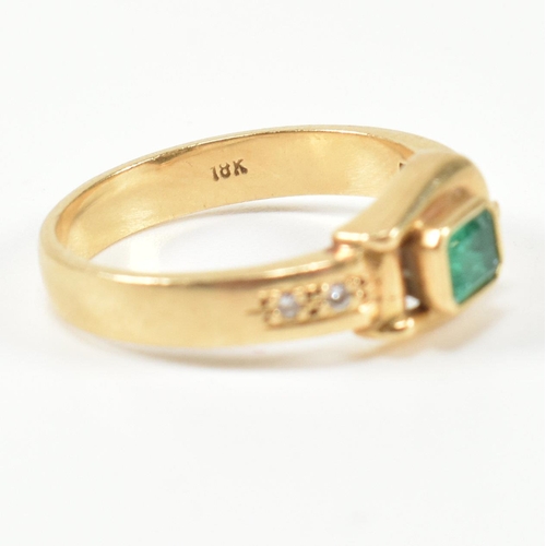 148 - An 18ct gold, diamond and emerald buckle ring. The gold buckle ring having a bezel set east-west eme... 