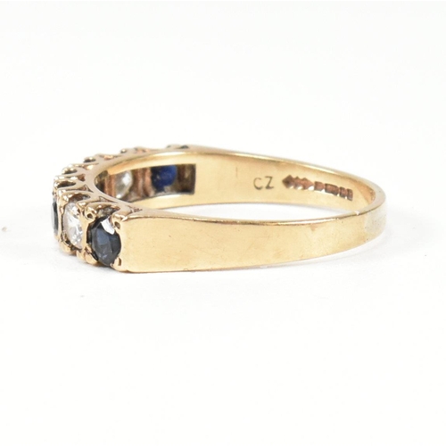 151 - A hallmarked 9ct gold, sapphire and CZ half hoop ring. The ring set with four round cut sapphires in... 