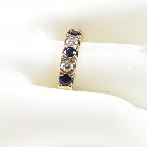 151 - A hallmarked 9ct gold, sapphire and CZ half hoop ring. The ring set with four round cut sapphires in... 