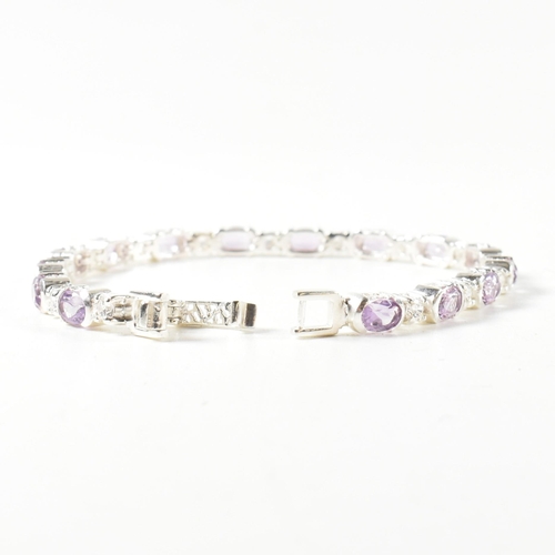 156 - A 925 silver, amethyst and CZ line bracelet. The bracelet set with half bezel set oval cut amethysts... 