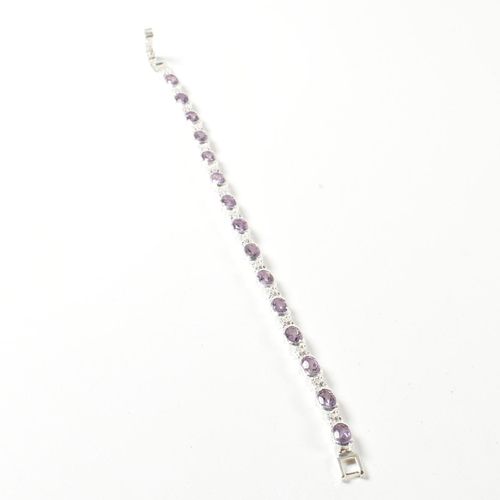 156 - A 925 silver, amethyst and CZ line bracelet. The bracelet set with half bezel set oval cut amethysts... 