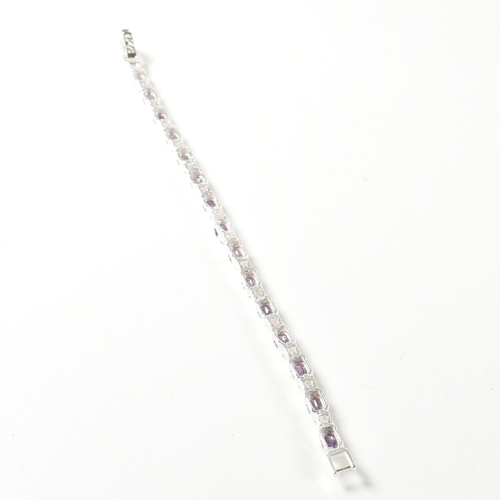 156 - A 925 silver, amethyst and CZ line bracelet. The bracelet set with half bezel set oval cut amethysts... 