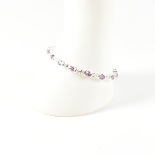 156 - A 925 silver, amethyst and CZ line bracelet. The bracelet set with half bezel set oval cut amethysts... 