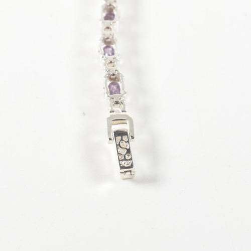 156 - A 925 silver, amethyst and CZ line bracelet. The bracelet set with half bezel set oval cut amethysts... 