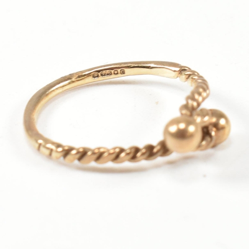 160 - A hallmarked 9ct gold rope twist ring. The ring having a twisted rope design with two metalwork bead... 