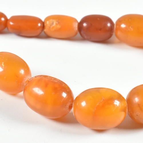 17 - An vintage amber bead necklace. The amber necklace having graduating oval beads strung with later cl... 