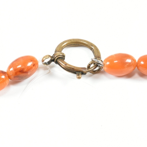 17 - An vintage amber bead necklace. The amber necklace having graduating oval beads strung with later cl... 