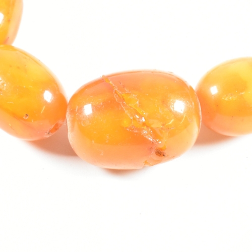 17 - An vintage amber bead necklace. The amber necklace having graduating oval beads strung with later cl... 